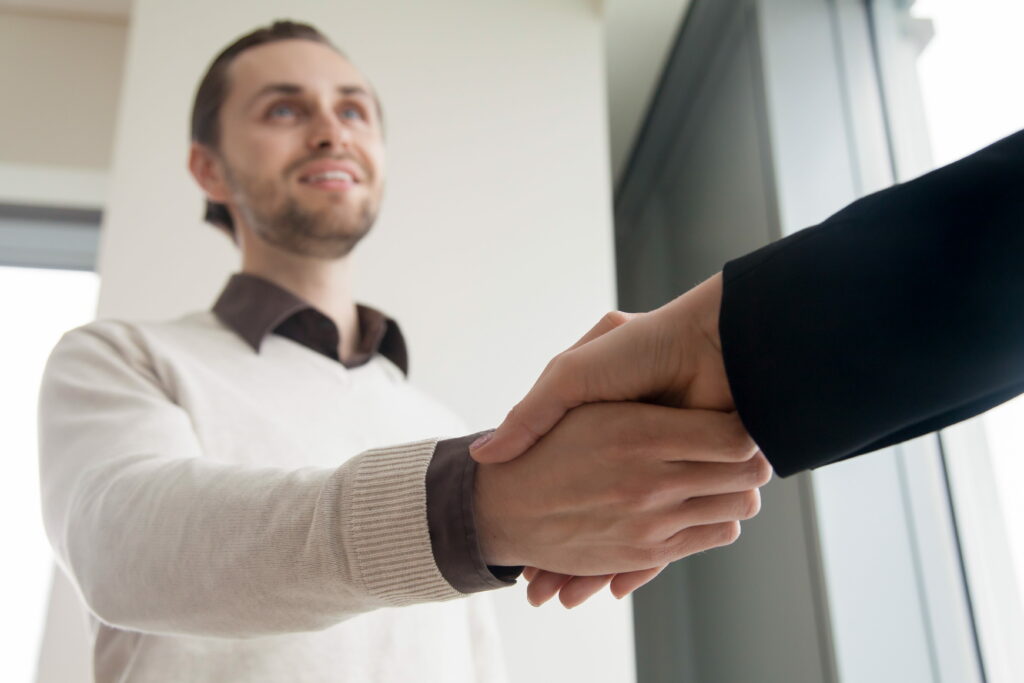 Handschlag zwischen Unternehmen und Fachkraft bei erfolgreicher Personalvermittlung
